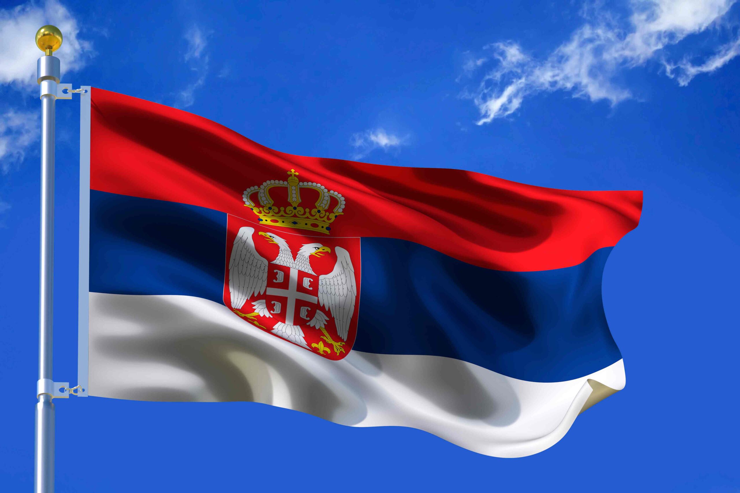 Zastava Srbije na jarbolu ispred vedrog neba